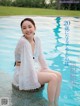 A woman sitting on the edge of a swimming pool.