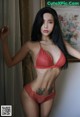 A woman in a red lingerie posing for a picture.